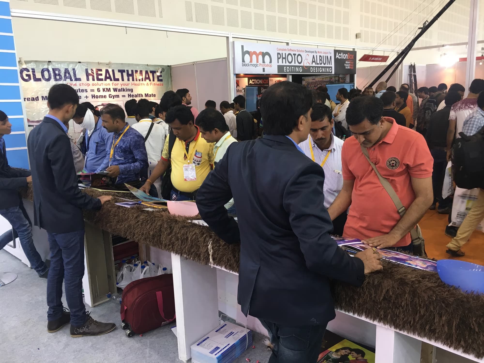 Photographers browsing printed albums laid out on the Prizam Digital Press counter