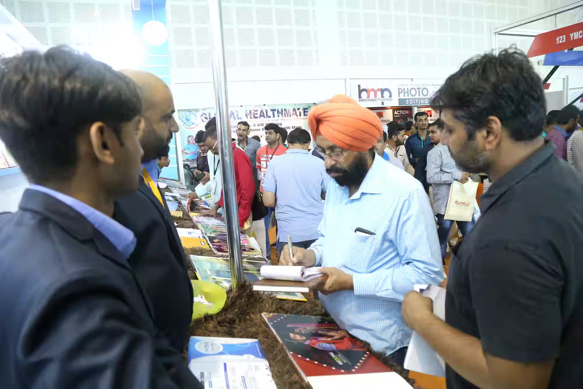 A visitor noting album specifications at the Prizam Digital Press counter
